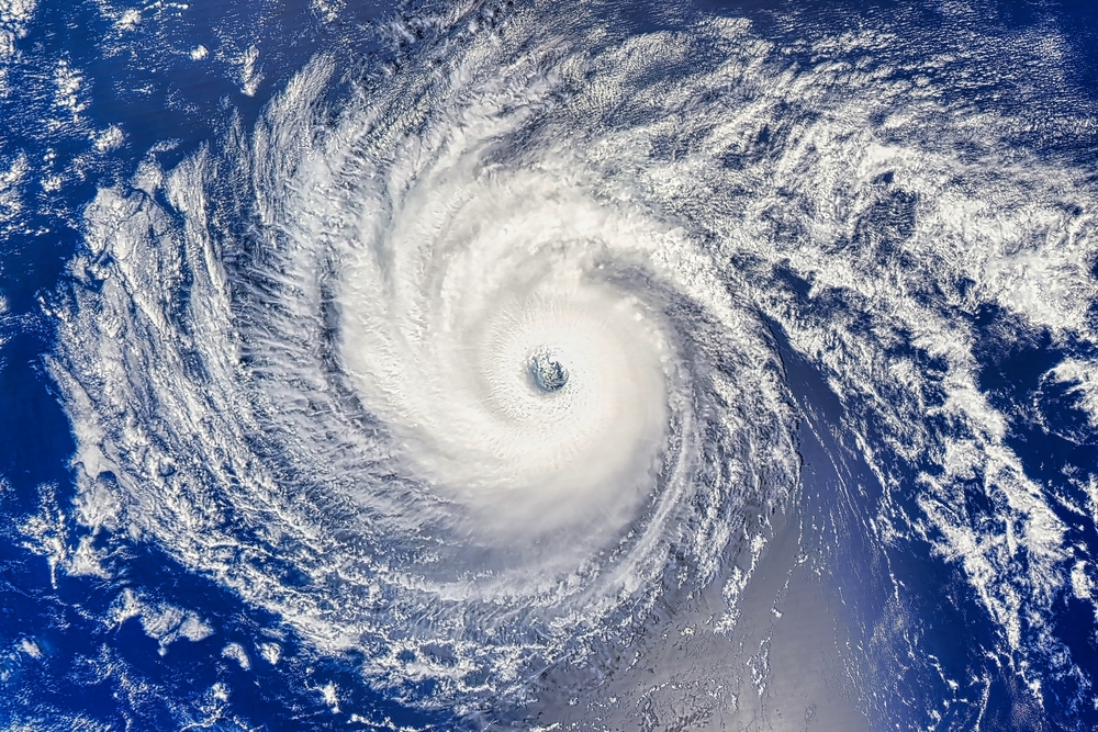 Satellite view of a large hurricane over the ocean, showing a distinct eye in the center surrounded by spiraling clouds.